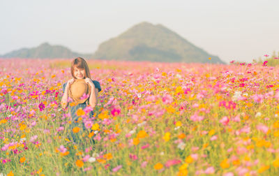 Portrait of woman standing amidst blooming flowers