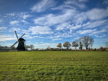 Windmill on field against sky