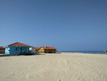 Scenic view of beach against clear blue sky