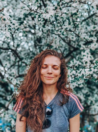 Portrait of smiling young woman against plants