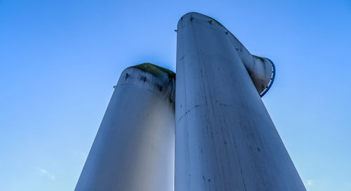 Low angle view of factory against clear blue sky