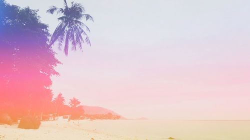 Scenic view of beach against sky at sunset