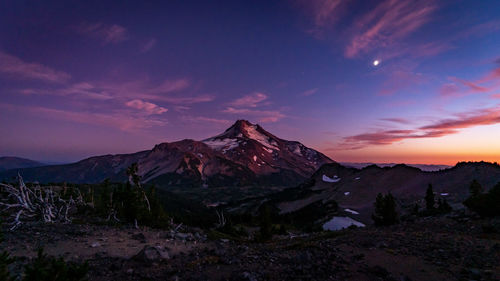 Scenic view of snowcapped mountains against sky during sunset
