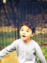 Surprised boy looking up while playing at park