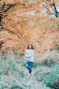 Portrait of a young woman standing on ground