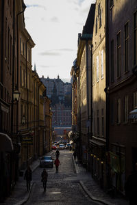 Street amidst illuminated city against sky