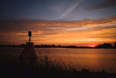 Scenic view of lake against orange sky