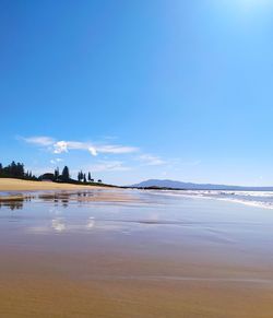 Scenic view of beach against blue sky