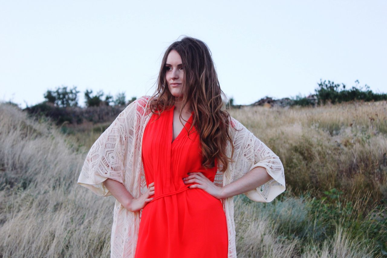 young adult, young women, long hair, lifestyles, casual clothing, person, leisure activity, three quarter length, standing, red, field, grass, waist up, smiling, front view, looking at camera, brown hair