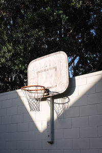 Low angle view of basketball hoop against trees