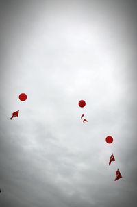 Low angle view of balloons flying against sky