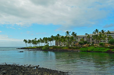 Scenic view of sea with hotel against sky