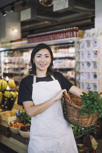 Portrait of young woman standing in supermarket