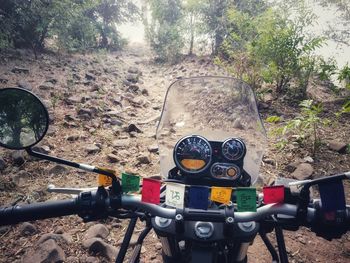 Close-up of bicycle on dirt road in forest