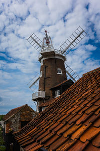 Low angle view of traditional windmill against sky