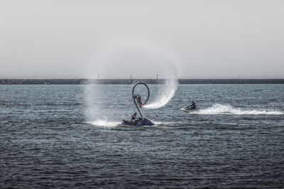 Man surfing in sea against clear sky