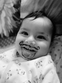 Portrait of cute baby boy with artificial beard on face 