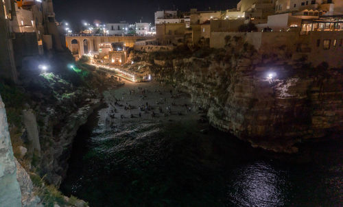 High angle view of illuminated street amidst buildings at night