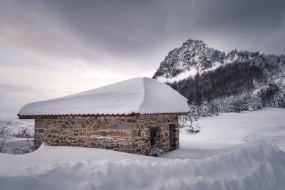 Built structure on snow covered building against sky