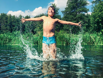 Young boy splashing in river