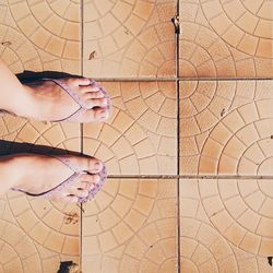 Low section of people standing on tiled floor