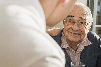 Portrait of smiling senior man face to face with his geriatric nurse