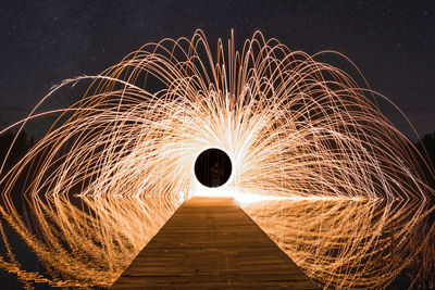 Low angle view of fireworks against sky at night