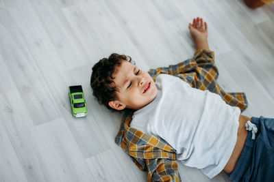 High angle view of boy lying on floor at home