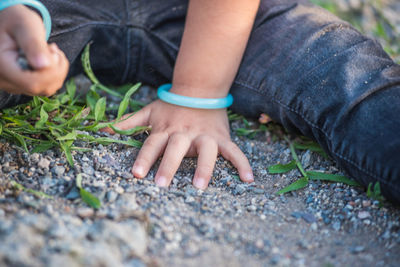 Midsection of child sitting outdoors