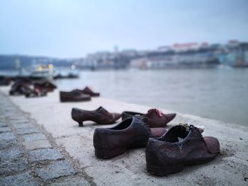 Close-up of shoes on riverbank