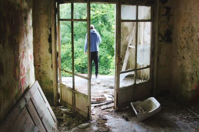 Man outside an obsolete house