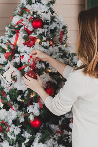 Cropped image of woman decorating christmas tree