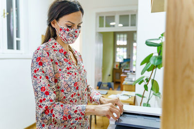 Young woman using mobile phone at home