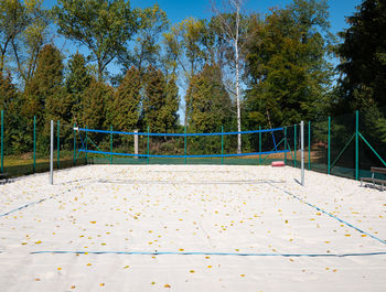 Empty volley ball court within fall season. dry leaves on the sand.
