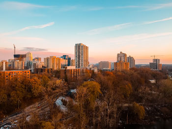 Buildings in city against sky during sunset