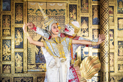 People in traditional clothing while dancing in temple