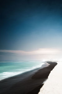 Scenic view of beach against clear sky at sunset