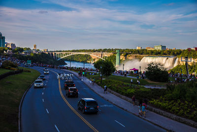 Traffic on road against cloudy sky