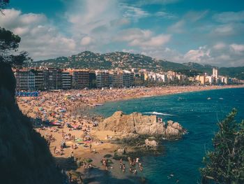 Aerial view of townscape by sea against sky