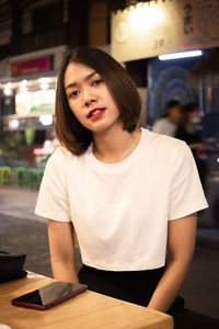 Portrait of beautiful young woman sitting at outdoor cafe