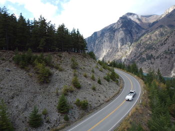 Scenic view of road by mountains against sky