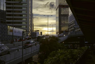 Modern buildings in city against sky during sunset