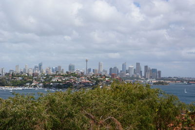 View of buildings in city against cloudy sky