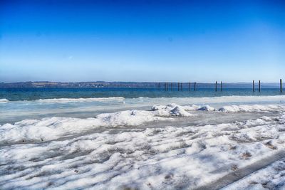 Scenic view of frozen sea against clear blue sky