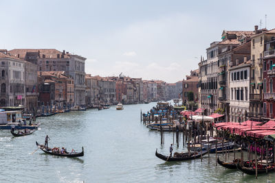 Gondolas in grand canal amidst buildings