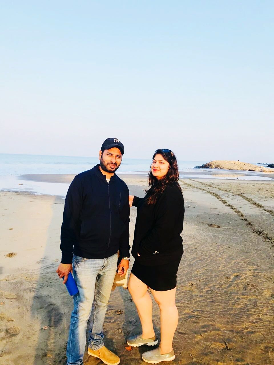 real people, two people, sea, standing, happiness, lifestyles, casual clothing, looking at camera, beach, smiling, clear sky, leisure activity, mature men, mid adult, full length, mid adult men, togetherness, mature adult, hands in pockets, mature women, front view, sky, outdoors, nature, day, portrait, young women, horizon over water, young adult, water, people