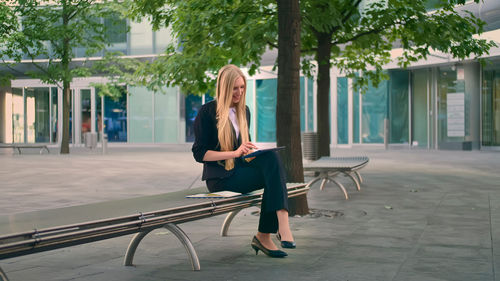 Woman sitting on seat in city