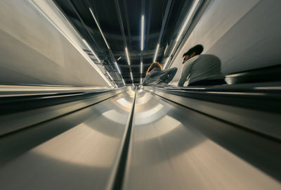 Low section of people on illuminated escalator