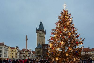 Christmas tree in city against sky