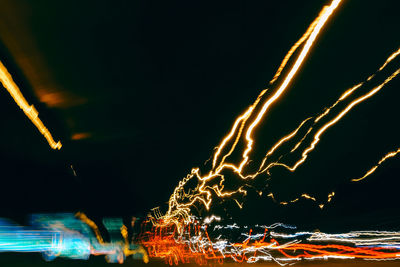 Low angle view of illuminated fireworks against sky at night